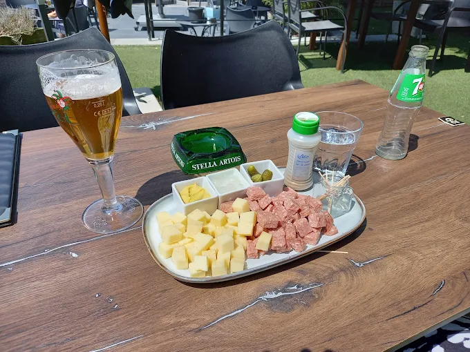 Kaas en salami met een glas bier op het terras